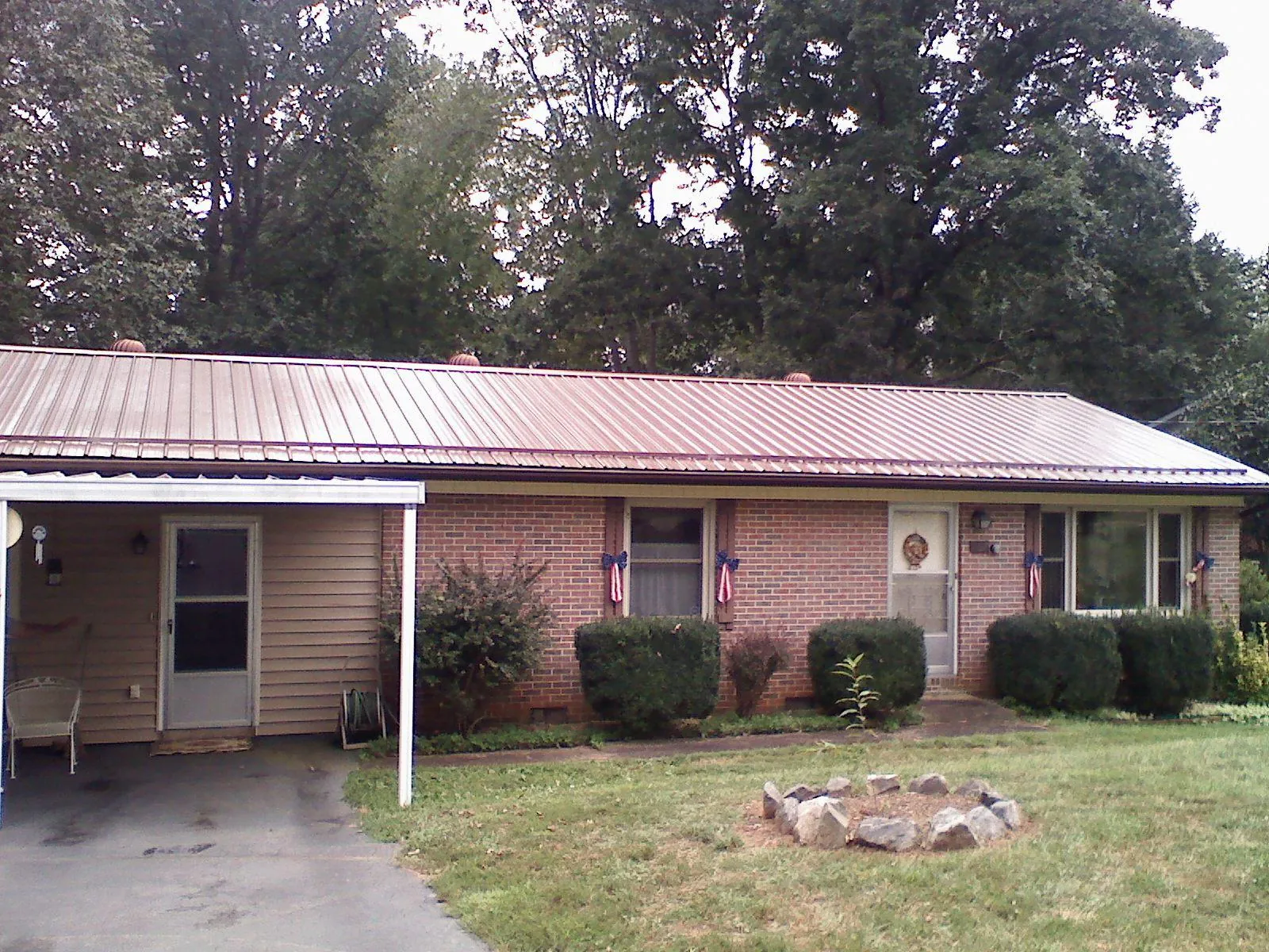 Bronze metal roof and carport on a brick ranch home — Roof Repair work by our crew in Parksville