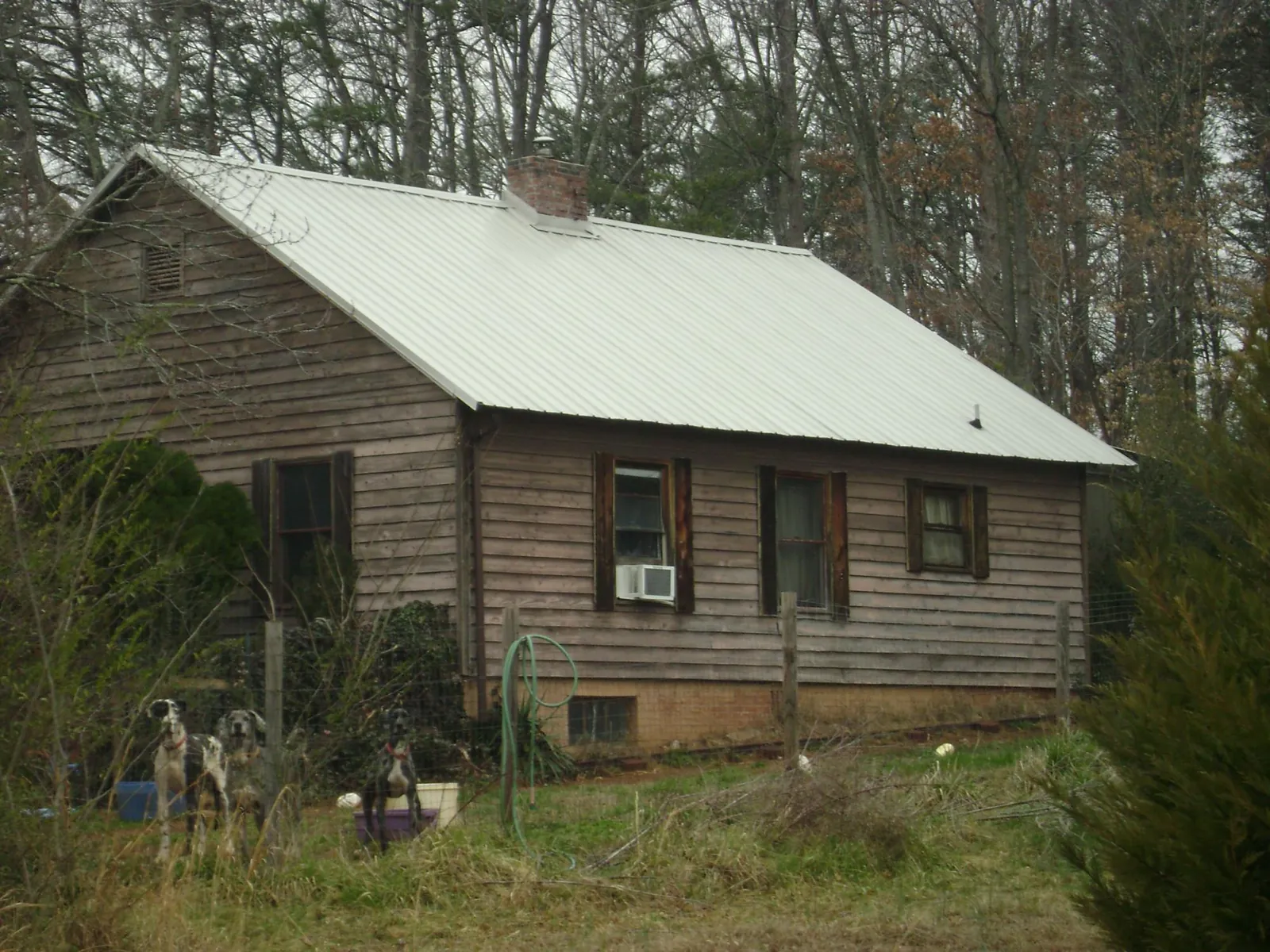 White metal roof on an old wood sided farmhouse, from a Metal Roof Installation job in Parksville
